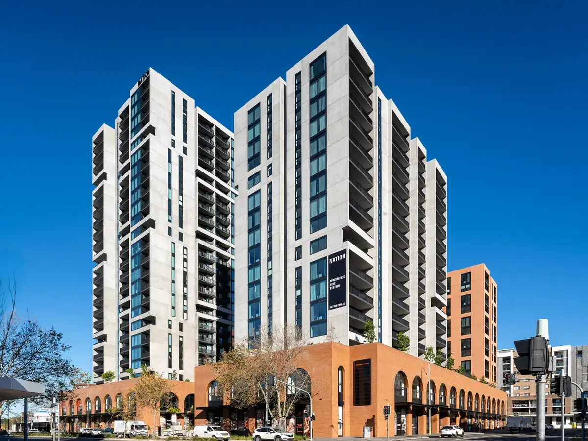 Two residential towers above an arched brick retail podium